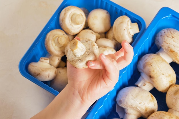 De handen van kinderen houden champignons van dichtbij vast