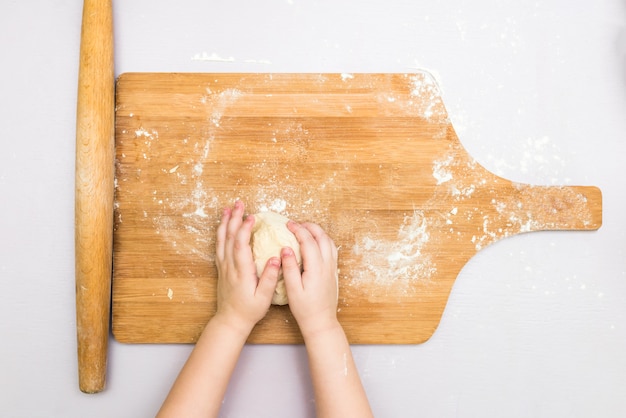 De handen van kinderen maken een deeg