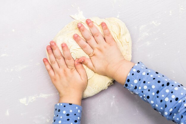 De handen van kinderen maken een deeg