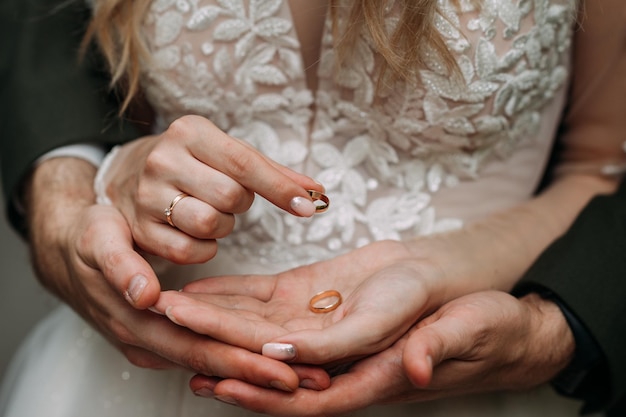 De handen van pasgetrouwden omarmen met trouwringen 4377