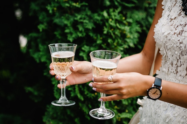 De handen van vrouwen houdt een glas champagne en bruid