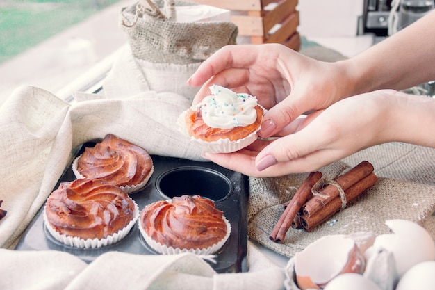 De handen van vrouwen nemen één van cupcake