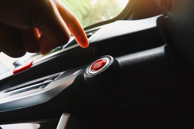 De handpalm van de bestuurder wanneer deze op de start-stopknop van de elektrische auto in een auto drukt