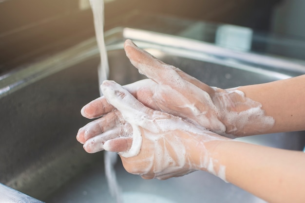 Foto de handwas van de vrouw met zeep antibacterieel voor tegen de hygiëneconcept van infectiekiemen.