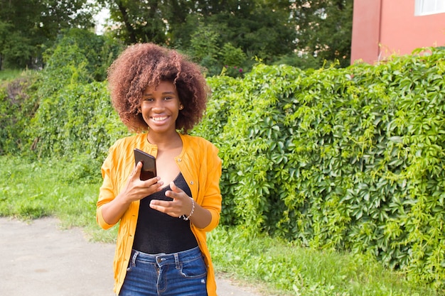 De Happy African American vrouw op straat praten aan de telefoon
