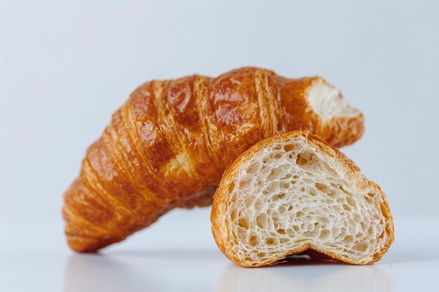 De helft van een croissant geïsoleerd op een achtergrond van een hele croissant op een witte achtergrond