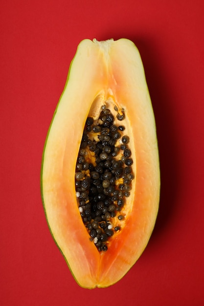 De helft van rijpe papaja op rode achtergrond