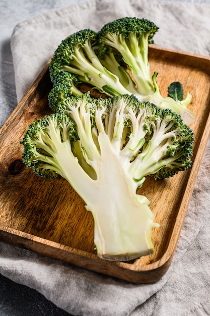 De helften verse broccoli in een houten kom. Grijze achtergrond. Bovenaanzicht