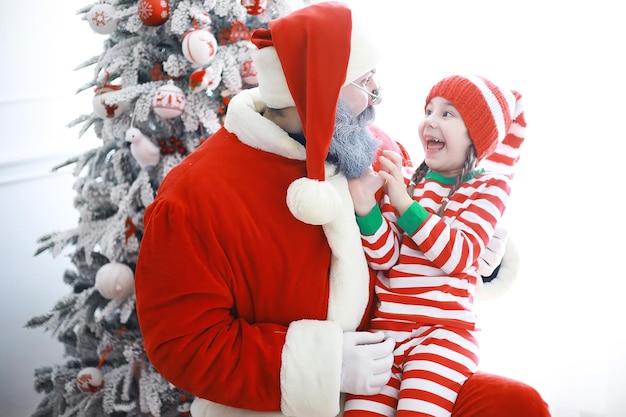 De helpers van de kerstman. Schattige kinderen in kerst elf kostuums in een kamer prachtig versierd voor Kerstmis. Tijd van wonderen. Cadeautjes van Sinterklaas.