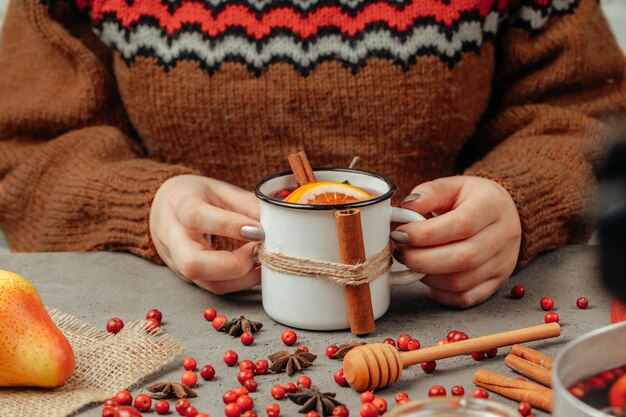 De hete muilled wijn in de handen van de vrouw sluit omhoog