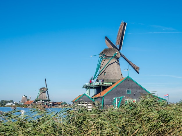Foto de historische klassieke windmolen genaamd de kat (the cat) in zaan schans, nederland