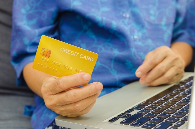 De hogere creditcards van de vrouwenholding op laptop