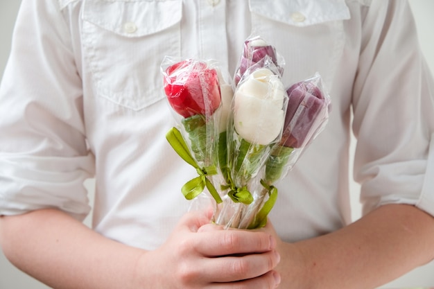 De holdingslollys van het meisje in de vorm van bloemen