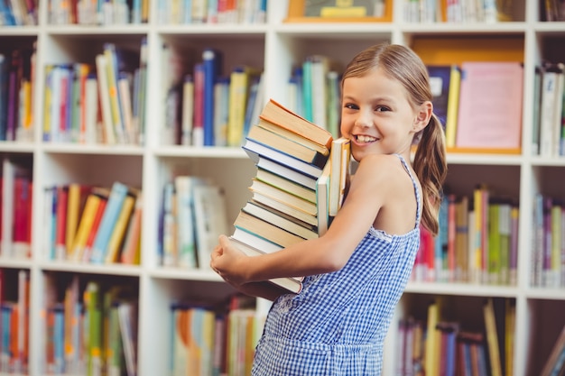 De holdingsstapel van het schoolmeisje boeken in bibliotheek