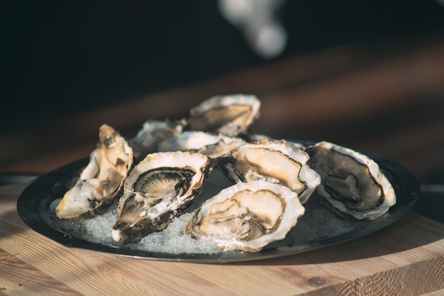 De holle en platte oesters openen. Chef-kok opent oesters in het restaurant.