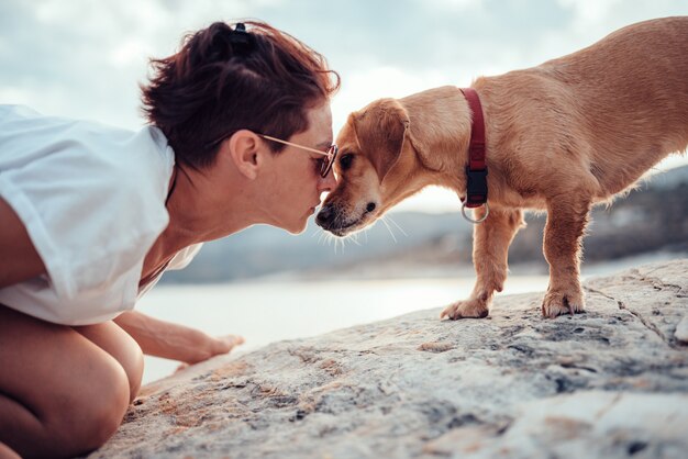 De hond nestelt zich met vrouw op het strand