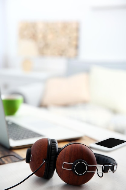 Foto de hoofdtelefoons en laptop op witte lijst tegen defocused achtergrond