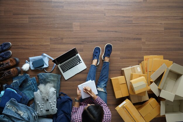 De hoogste mening van vrouwen schrijft een notitieboekje op houten vloer met, die online ideeënconcept verkopen