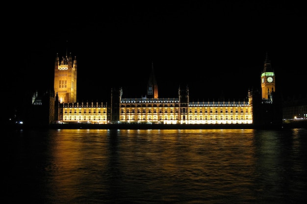 De Houses of Parliament en de Big Ben vanaf de andere kant van de Theems 's nachts