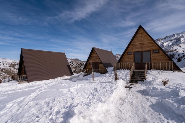 De houten huisjes omgeven door sneeuw Een recreatiegebied in de bergen