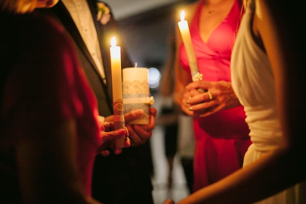 de huwelijkstraditie van de overdracht van vuur door de familie. pasgetrouwden houden kaarsen in hun handen