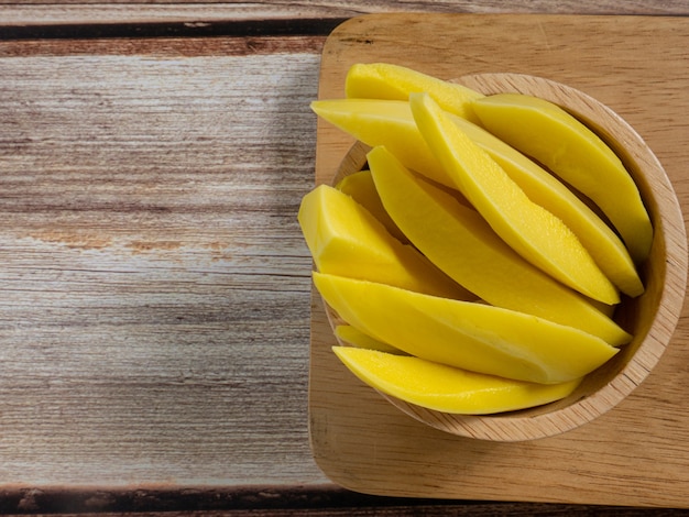 De ingemaakte mango Thailand in kom op houten tafel voor voedselinhoud.