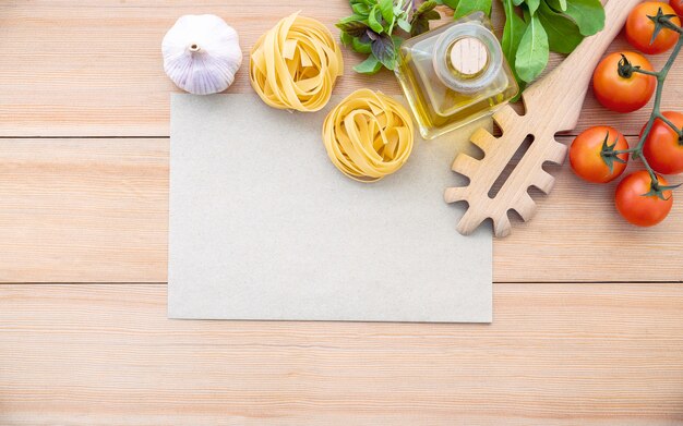 De ingrediënten voor huisgemaakte pasta met kopie ruimte op houten tafel.