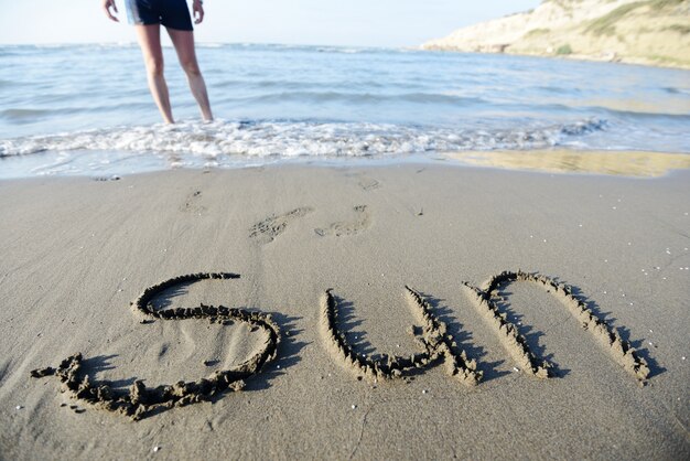 Foto de inscriptie op het zand met een prachtige surf - vakantie!