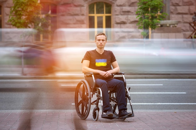 De invalide man zit in de rolstoel in de buurt van de weg