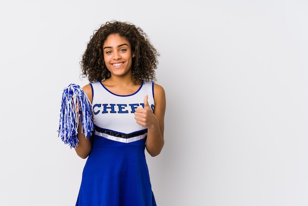 De jonge Afrikaanse Amerikaanse cheerleadervrouw isoleerde omhoog het glimlachen en het opheffen van duim
