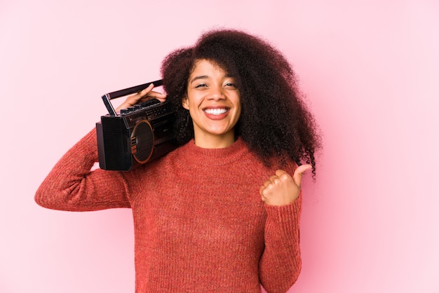 De jonge afrovrouw die een cassete houden isoleerde omhoog glimlachend en duim opheffend