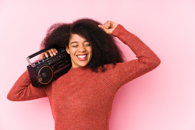 De jonge afrovrouw die een cassete houden isoleerde vuist na een overwinning, winnaarconcept.