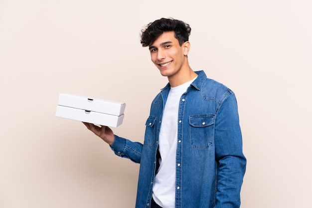 De jonge Argentijnse pizza's van de mensenholding over geïsoleerde muur die heel wat glimlachen