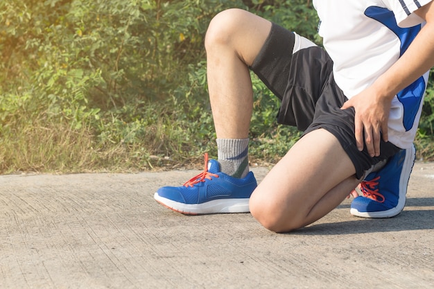 De jonge Aziatische bindende loopschoenen van de atletenmens vooraan huis, mannelijke agent klaar voor jogging