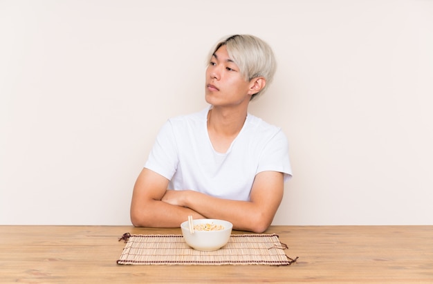 De jonge Aziatische mens met ramen in een lijst die kant kijkt