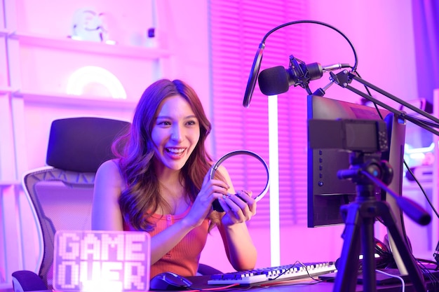 De jonge Aziatische mooie vrouw Pro Gamer zingt en chat live met haar fans thuis