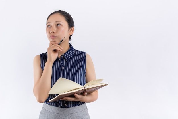 De jonge Aziatische vrouw met een boek behandelt haar gezicht
