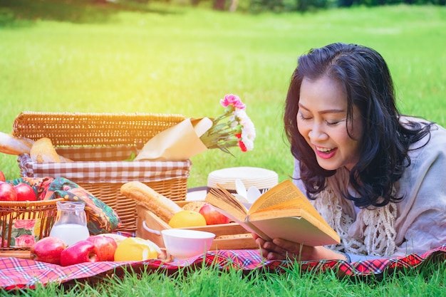 De jonge Aziatische vrouw ontspant tijd in park.