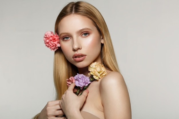 De jonge bloemen van de vrouwenholding en het stellen in een studio