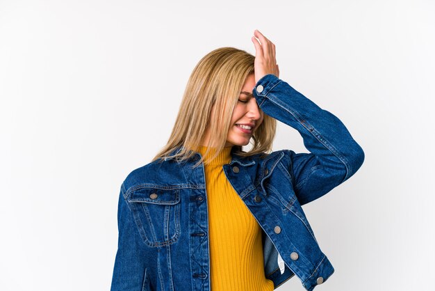 De jonge blonde kaukasische vrouw isoleerde het vergeten van iets, slaand voorhoofd met palm en sluitende ogen.