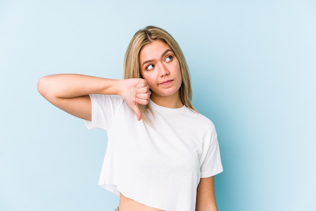 De jonge blonde Kaukasische vrouw isoleerde neer tonend duim, teleurstellingconcept.