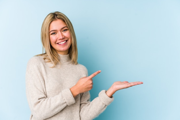 De jonge blonde Kaukasische vrouw isoleerde opgewekt het houden van een exemplaarruimte op palm.