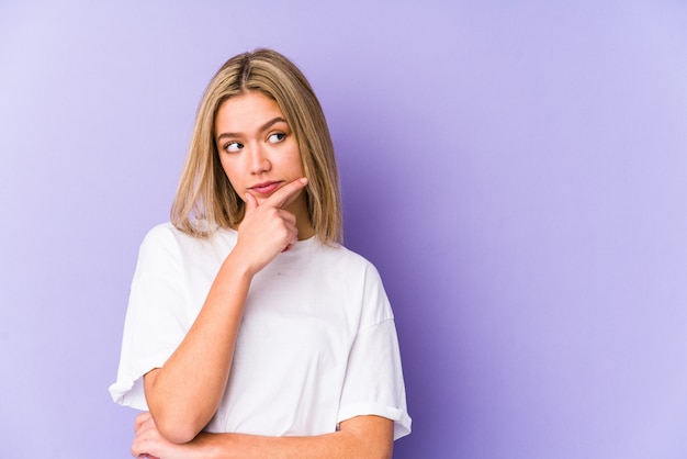 De jonge blonde Kaukasische vrouw isoleerde zijdelings het kijken met twijfelachtige en sceptische uitdrukking.