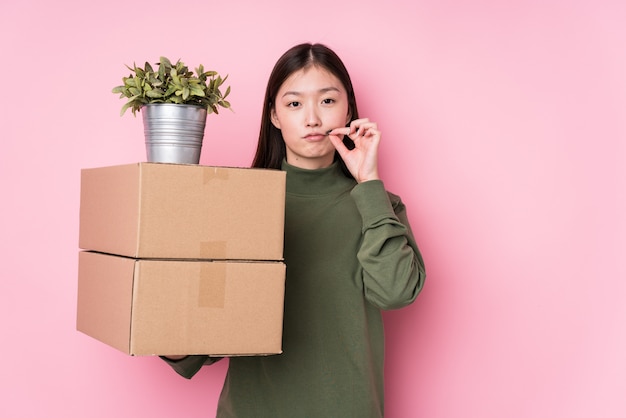 De jonge chinese dozen van de vrouwenholding die met vingers op lippen worden geïsoleerd die een geheim houden.