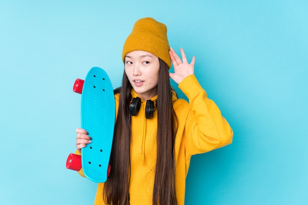 De jonge Chinese schaatservrouw isoleerde het proberen aan het luisteren van een roddel.