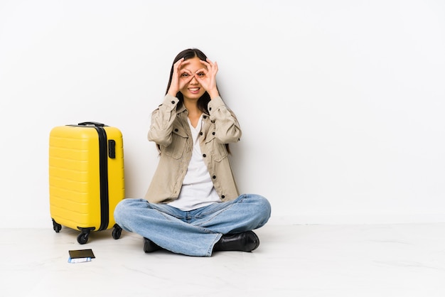 De jonge Chinese zitting die van de reizigersvrouw instapkaarten houden die ok teken over ogen tonen