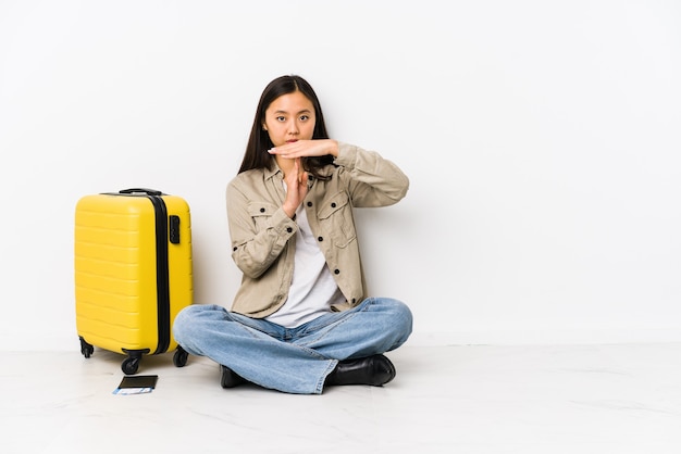 De jonge Chinese zitting die van de reizigersvrouw instapkaarten houdt