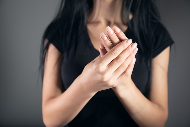 De jonge droevige vrouw doet pijn aan haar vinger.