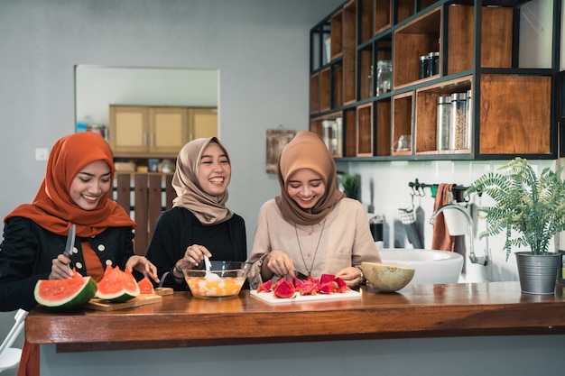 De jonge hijabvrouw bereidt vruchten voor om cocktail te maken