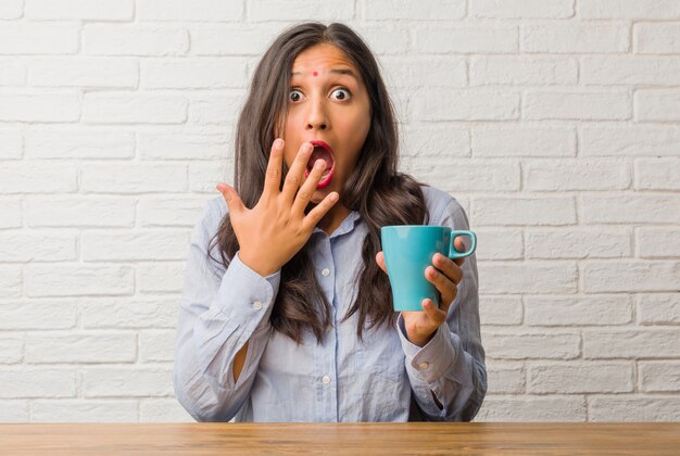 De jonge Indische verrast en geschokte vrouw, kijkend met brede ogen, opgewekt door een aanbieding of door een nieuwe baan, wint concept